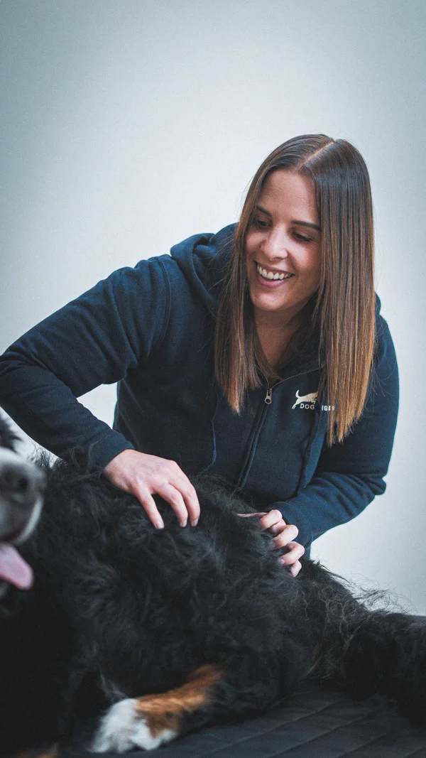 Sarah, massothérapeute canine certifiée et comportementaliste, souriant avec son chien Vibe